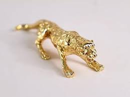 Gold panther figurine on a light gray background